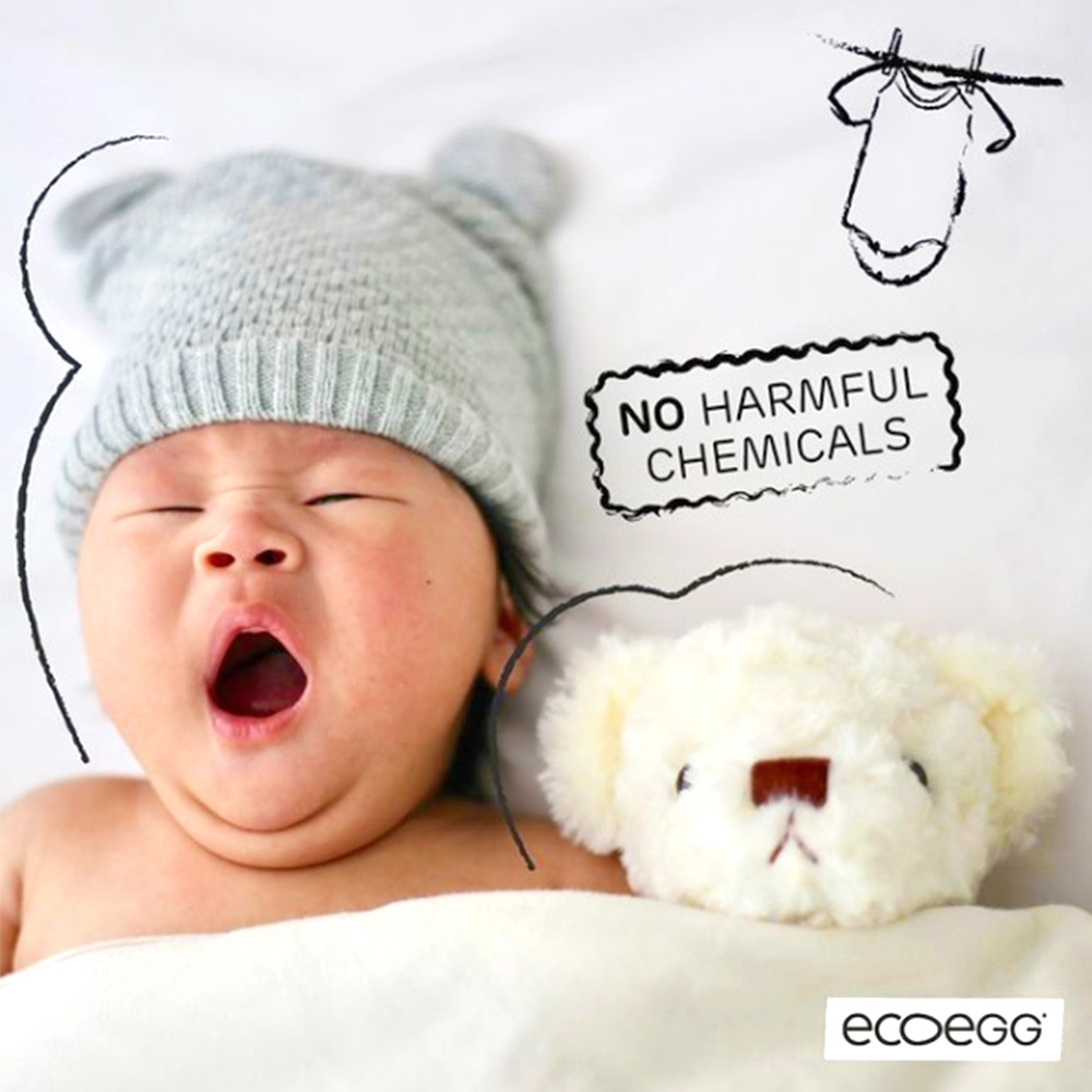 a baby yawning with a teddy bear and the ecoegg logo